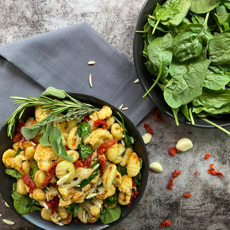 Crispy Gnocchi and Cauliflower Skillet; Simple, yet tasty dish of gnocchi, cauliflower, kale and sun-dried tomatoes. Sautéed in garlic-herb plant based butter and topped with toasted slivered almonds, this dish is full of flavor. A family dinner pleaser. 